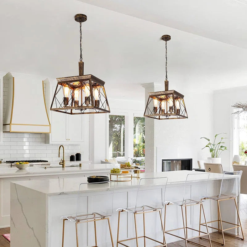 Four light bronze lantern pendant lights hanging in a modern interior, featuring intricate metalwork and warm bronze finish.