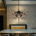 Modern Akzel 10 light pendant by TheChandelierCo with sleek metal frame and clear glass shades hanging from a ceiling mount.
