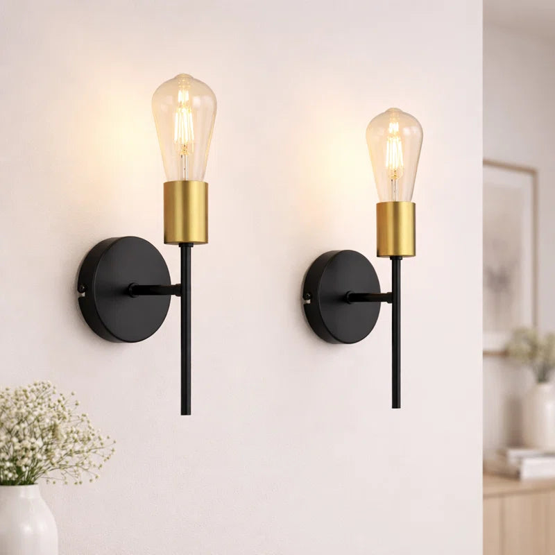 Set of two Ambellina iron armed wall sconces with vintage-style candle holders and intricate design for elegant lighting.