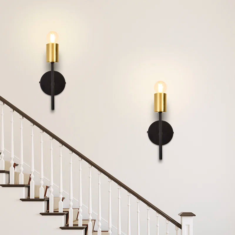 Pair of Ambellina iron armed sconces by TheChandelierCo with vintage-inspired metal arms and candle-style light holders.