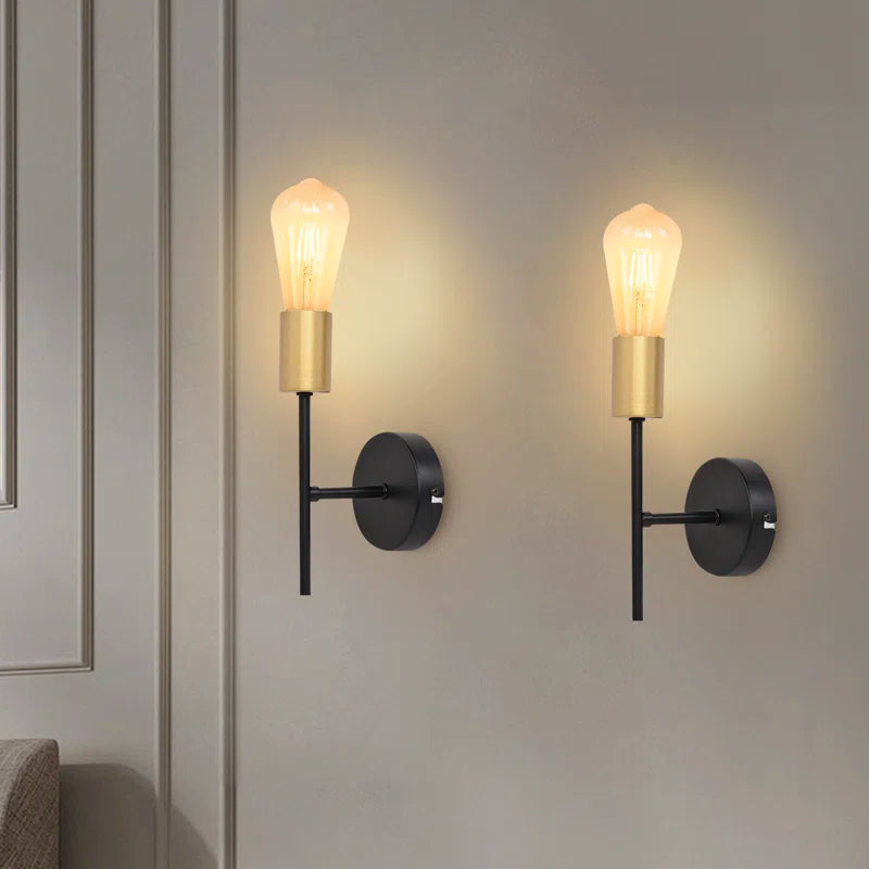 Set of two Ambellina iron armed sconces with classic design, featuring black iron arms and candle-style light fixtures.