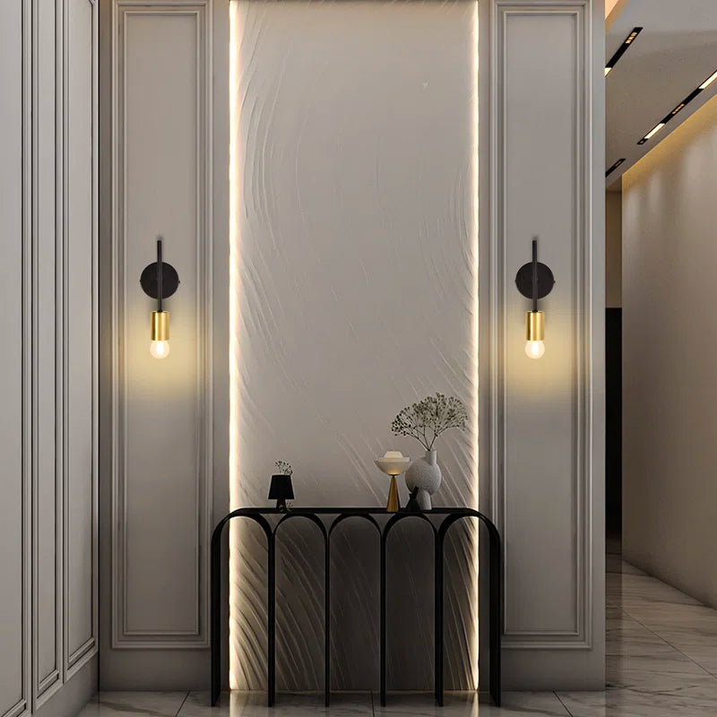 Set of two Ambellina iron armed sconces with vintage-style metal arms and candle-like light holders for wall lighting.
