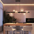 Light matte black sphere pendant light from the Ammanda 8 collection by TheChandelierCo, showcasing a modern, minimalist fixture.