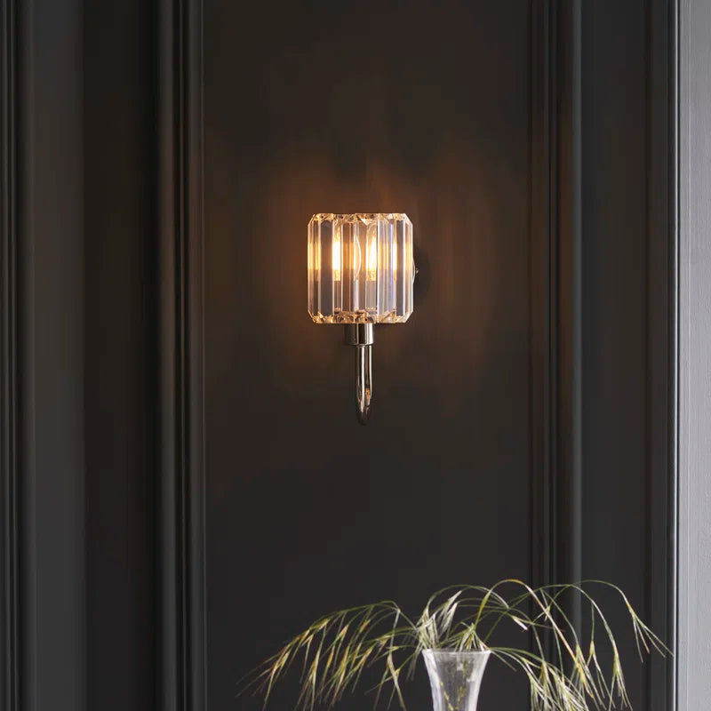 Steel and glass armed sconce by TheChandelierCo featuring a modern design with a sleek metal arm and clear glass shade.