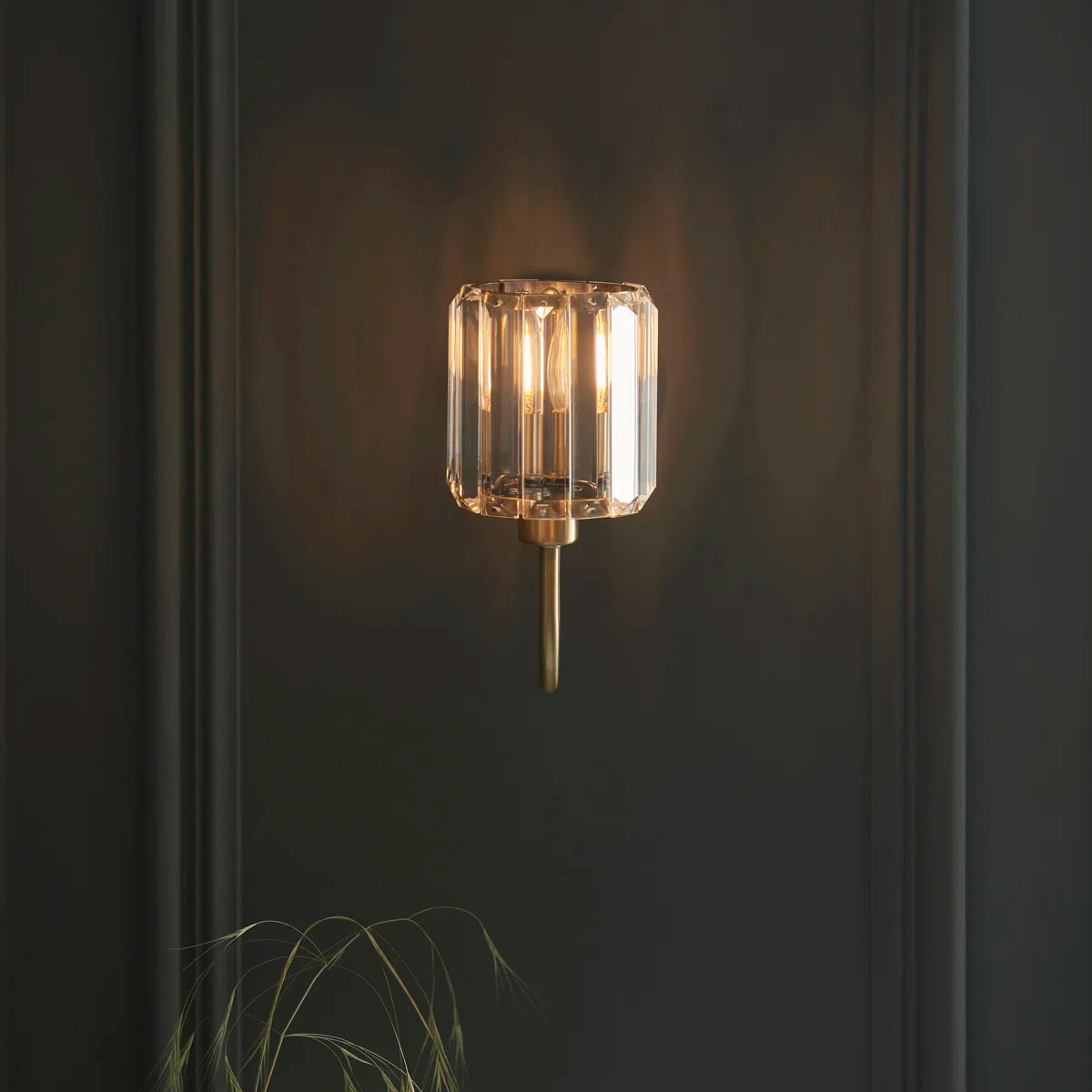 Steel and glass armed sconce by TheChandelierCo featuring a modern design with sleek metal arm and clear glass shade.