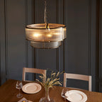 Anesty 5-light pendant chandelier by TheChandelierCo with antique brass finish, featuring sleek metal shades hanging from a central fixture.