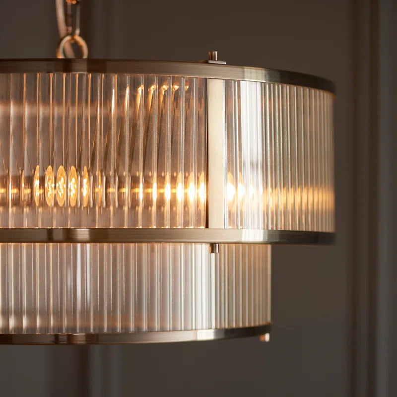 Anesty 5lt pendant light in antique brass finish with five hanging lights and decorative metal detailing.