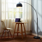 Bonita Arquer 66.93-inch arc floor lamp with faux black marble base and black bell shade in a modern living space.