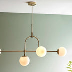 Five-light antique brass linear chandelier with modern design, featuring sleek metal arms and elegant light fixtures for stylish illumination.