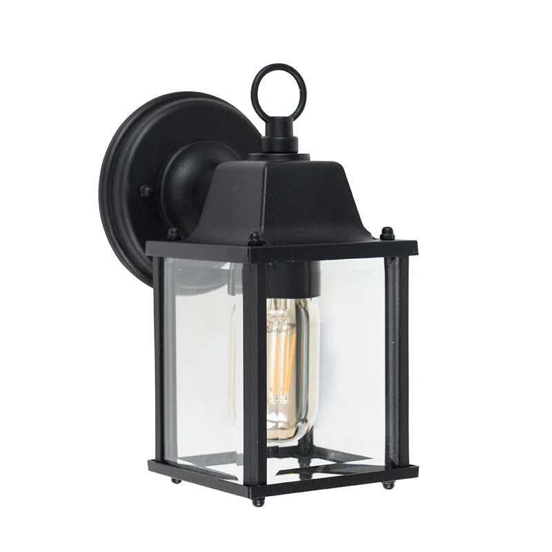 Black outdoor wall lantern by TheChandelierCo, featuring a classic design with glass panels and decorative metalwork.