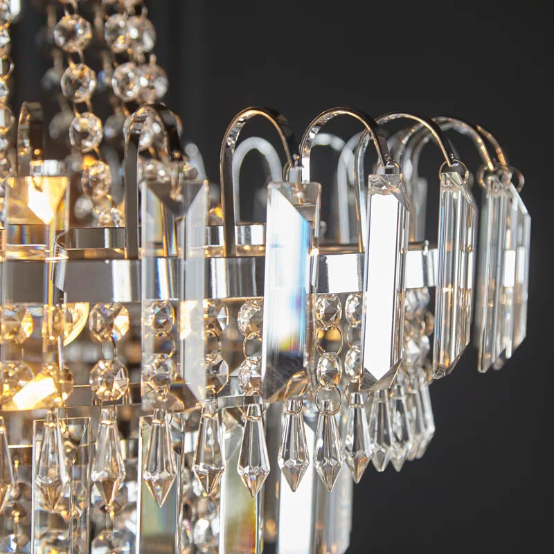 Jayla 6-light chandelier by TheChandelierCo featuring sleek metal frame and six elegant glass shades hanging from the fixture.