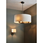 Katrina 3 light drum chandelier by TheChandelierCo featuring a modern drum shade with three warm light bulbs against a neutral background.