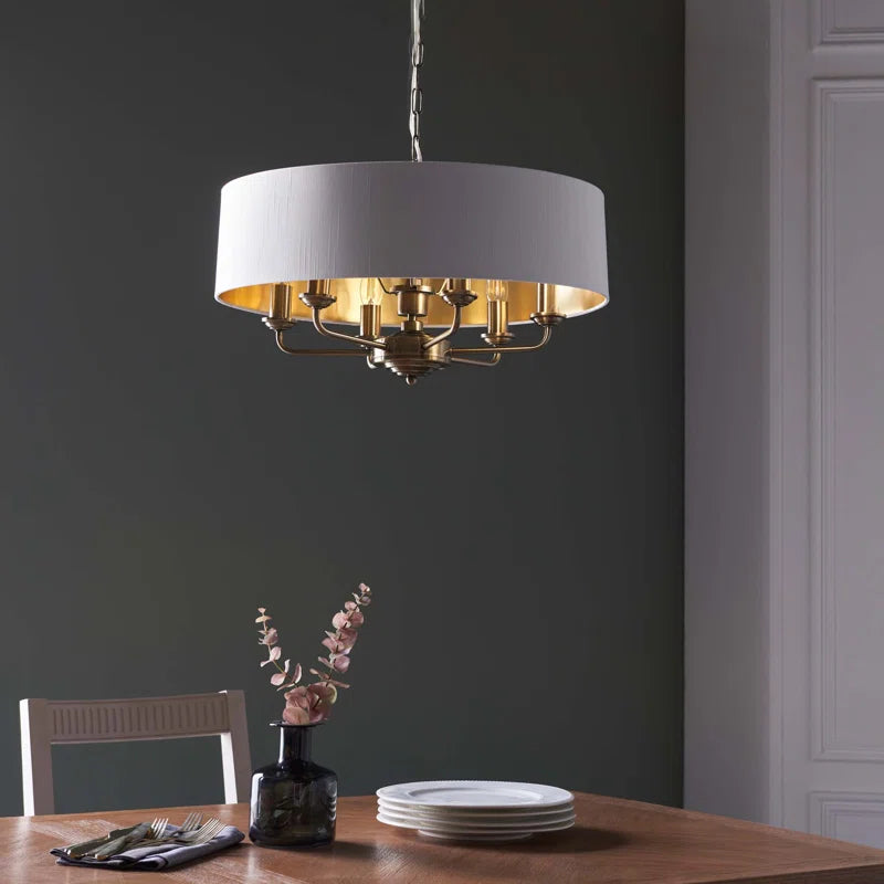 Light drum chandelier with six drum-shaped shades hanging from a sleek black frame, designed by TheChandelierCo.