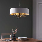 Light drum chandelier with six drum-shaped shades hanging from a sleek black frame, designed by TheChandelierCo.