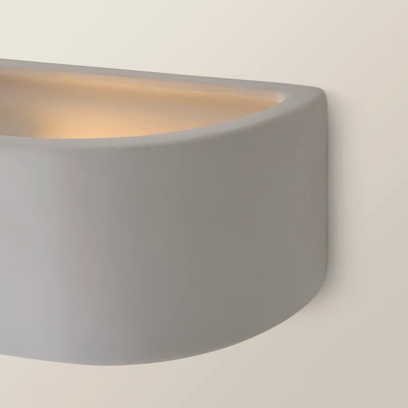 White ceramic Laura flush-mounted sconce by TheChandelierCo, featuring a modern design with a sleek, rounded shape and soft lighting.