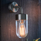 Myla 21cm outdoor wall lantern by TheChandelierCo with black metal frame and clear glass panels, mounted on exterior wall.