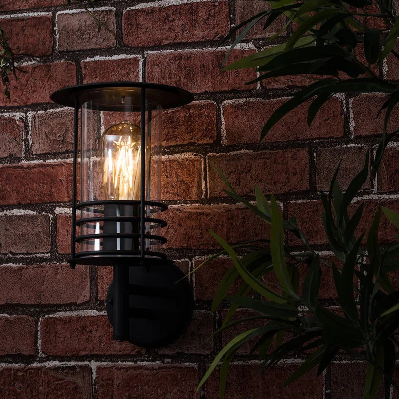 Black outdoor wall lantern with a classic design, featuring a rectangular frame and clear glass panels for outdoor lighting.