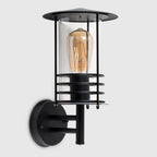 Black outdoor wall lantern with classic design, featuring a spruce head shape and clear glass panels by TheChandelierCo.