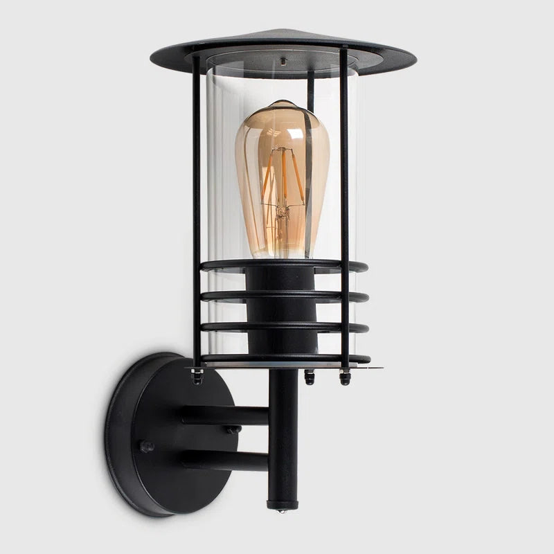 Black outdoor wall lantern with classic design, featuring a spruce head shape and clear glass panels by TheChandelierCo.